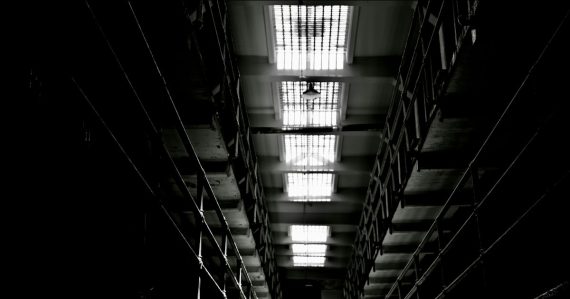 Dark, narrow hallway with bright, barred skylights, illustrating in-cell phones at HMP Birmingham