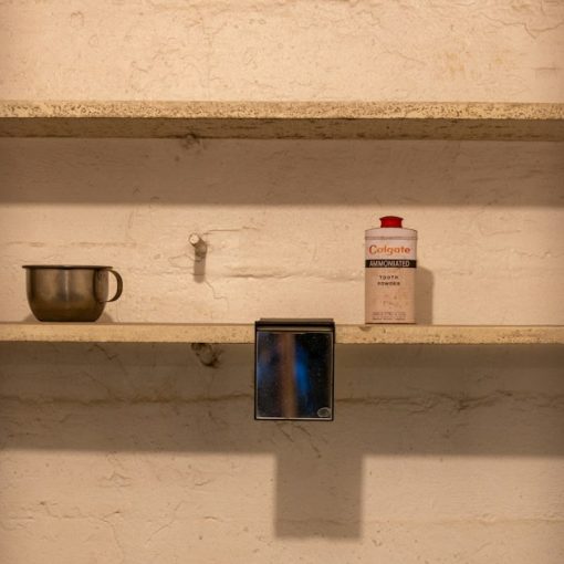 Items on shelves viewed through prison bars, illustrating phones reaching Texas death row