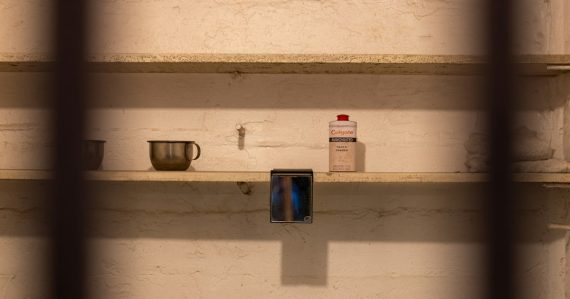 Items on shelves viewed through prison bars, illustrating phones reaching Texas death row