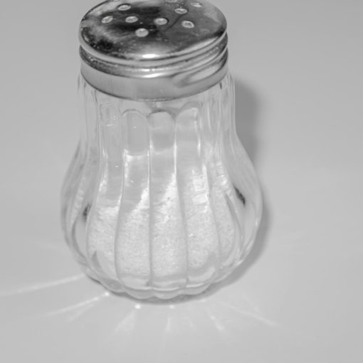 A salt shaker sitting on top of a table, illustrating salt disabling a prison phone jammer