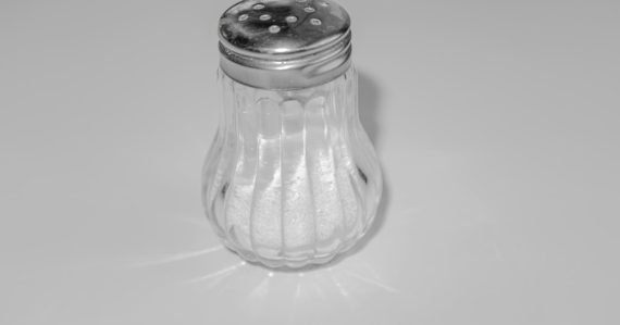 A salt shaker sitting on top of a table, illustrating salt disabling a prison phone jammer