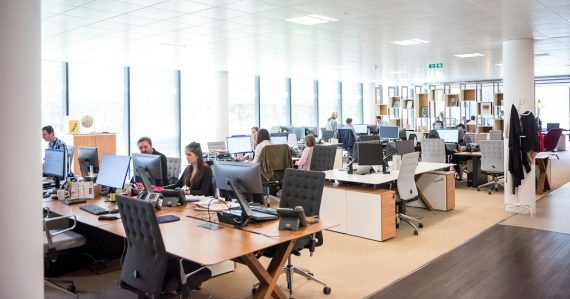 People working at desks in open office, illustrating Securus's sale to ABRY Partners