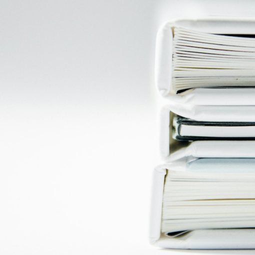 A stack of thick folders on a white surface, illustrating Securus suing Global Tel*Link