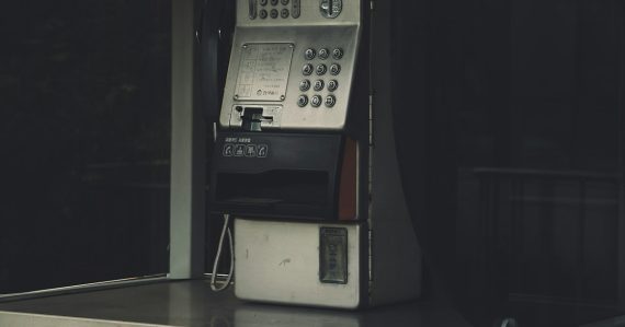A pay phone sitting on top of a counter, illustrating FCC action on site commissions