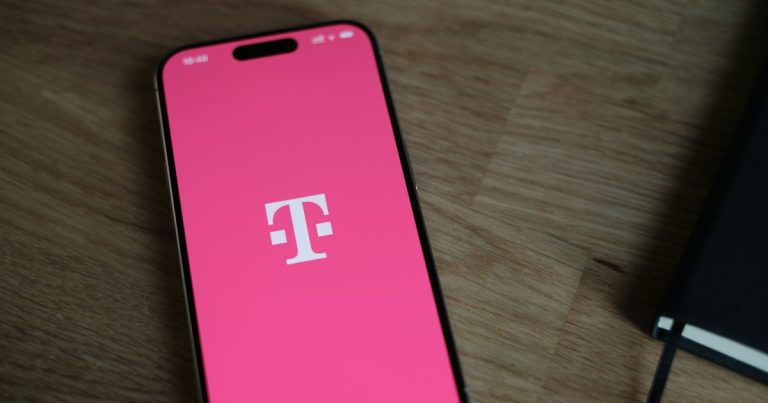 A pink phone sitting on top of a wooden table, illustrating a Nassau lawyer on smuggled phones