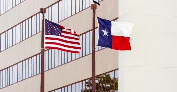 Texas Flag and USA flag on poles, illustrating a video on phones in Texas prisons