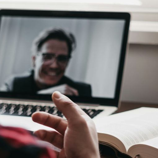 Person in a plaid shirt using a laptop computer, illustrating video visits replacing jail visits