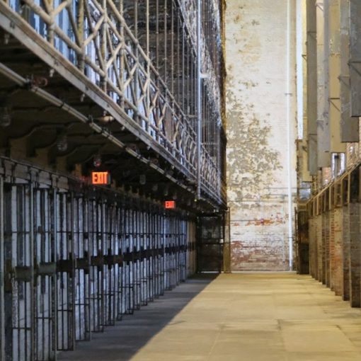 A long hallway with prison cells on the left, illustrating Ohio ending video visitation