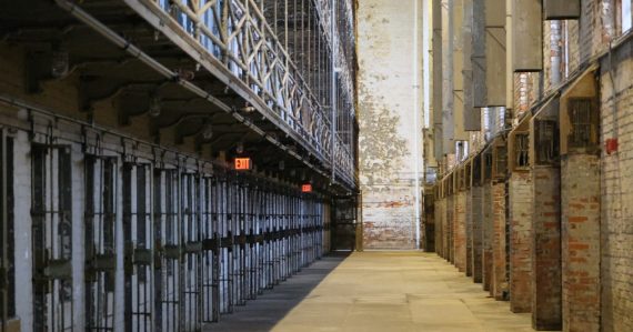 A long hallway with prison cells on the left, illustrating Ohio ending video visitation