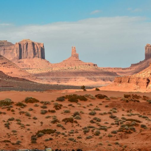 Red sandstone buttes and mesas rising from a desert landscape in Monument Valley, illustrating Arizona's inmate visitor fee