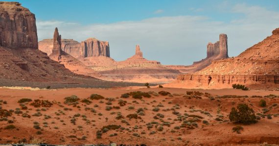 Red sandstone buttes and mesas rising from a desert landscape in Monument Valley, illustrating Arizona's inmate visitor fee