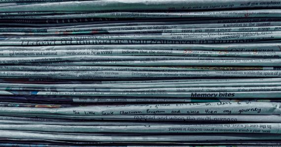 Pile of newspapers, illustrating contraband phone news briefs